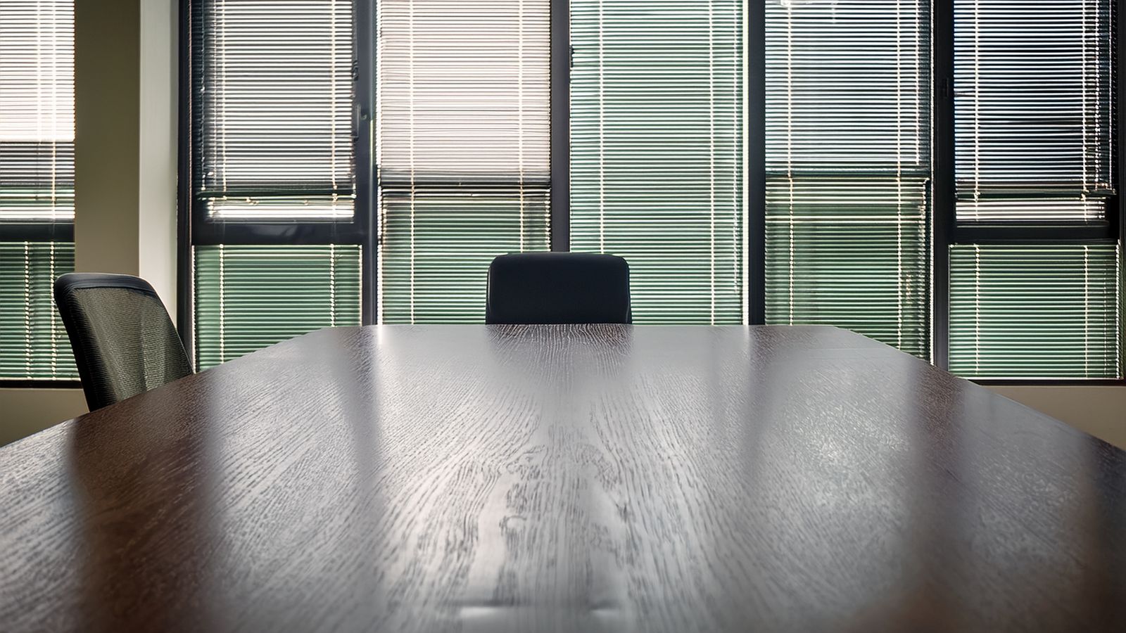An empty meeting room with one chair pulled away from the table